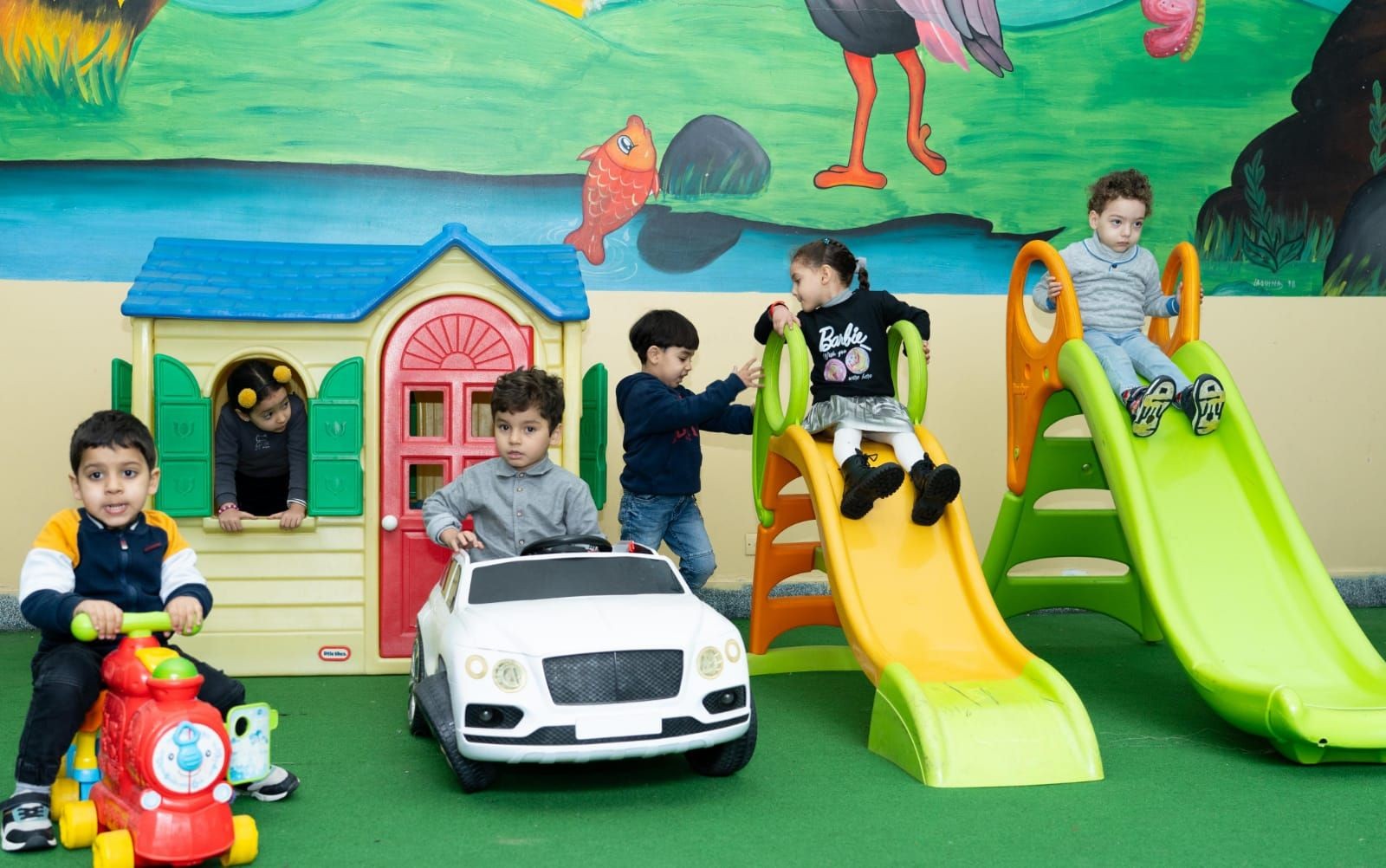 kids playing i a game parc with slides and mini cars 